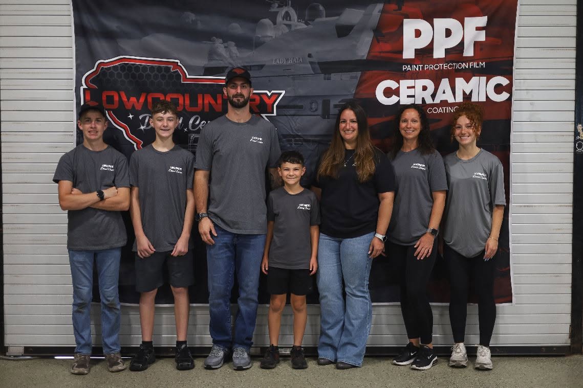 The Lowcountry Detail Center team in front of the shop's PPF and ceramic banner